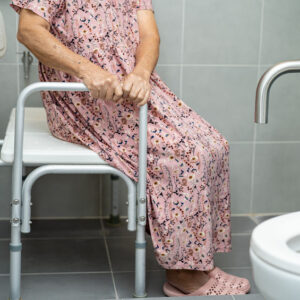 senior woman using shower seat and grab bar in shower