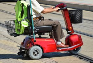 Old man with an electric wheelchair on the street