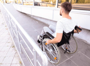 Young man in wheelchair on ramp outdoors