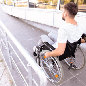 Young man in wheelchair on ramp outdoors