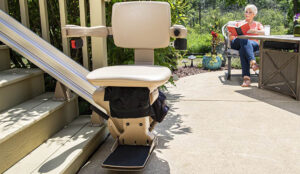 stairlift at bottom of stairs with woman in background