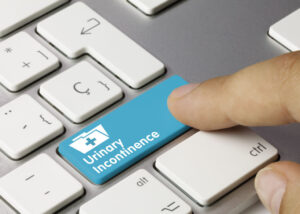 Urinary Incontinence Written on Blue Key of Metallic Keyboard. Finger pressing key.