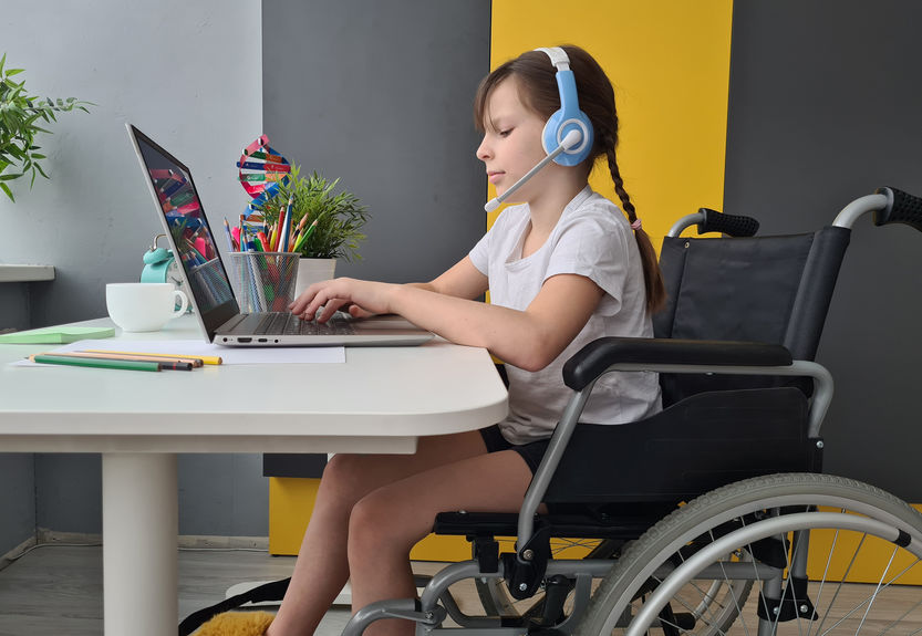 girl in wheelchair on video conference at home. Remote learning and communication with friends