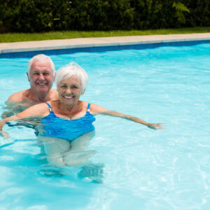 Portrait of happy senior couple in the pool on a sunny day