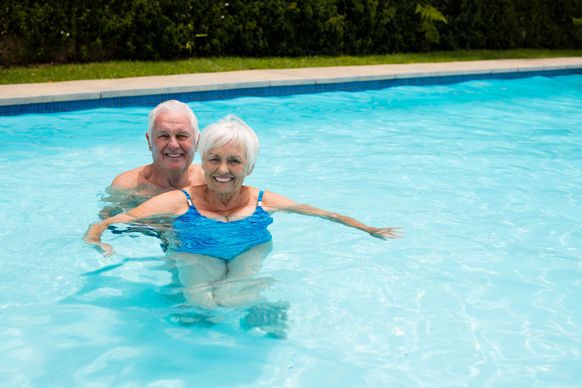 Portrait of happy senior couple in the pool on a sunny day
