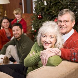 senior couple with family by Christmas tree