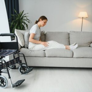 woman trying to sit down in wheelchair from couch
