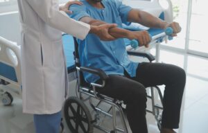 Doctor or physiotherapist working examining treating injured arm of athlete male patient, stretching and exercise, doing the rehabilitation therapy pain in clinic.