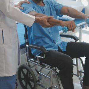 Doctor or physiotherapist working examining treating injured arm of athlete male patient, stretching and exercise, doing the rehabilitation therapy pain in clinic.